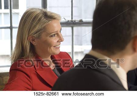 Businesswoman smiling with a businessman beside her View Large Photo Image Stock Image - Businesswoman smiling with a businessman beside her. Fotosearch