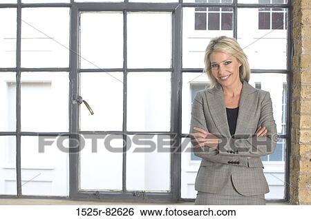 Businesswoman standing with her arms crossed and smiling View Large Photo Image Stock Photograph - Businesswoman standing with her arms crossed and smiling. Fotosearch