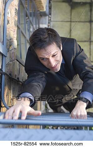 High angle view of a businessman climbing up a ladder View Large Photo Image Picture - High angle view of a businessman climbing up a ladder. Fotosearch