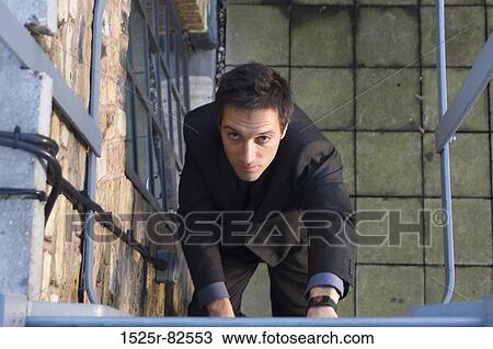 High angle view of a businessman climbing up a ladder View Large Photo Image Stock Image - High angle view of a businessman climbing up a ladder. Fotosearch