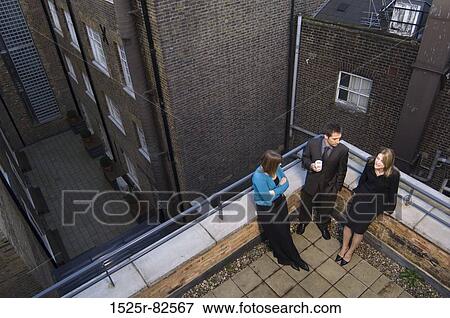 High angle view of a businessman with two businesswomen standing on the roof of a building View Large Photo Image Stock Photo - High angle view of a businessman with two businesswomen standing on the roof of a building. Fotosearch