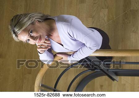 High angle view of a businesswoman leaning against a hand rail and smiling View Large Photo Image Stock Photo - High angle view of a businesswoman leaning against a hand rail and smiling. Fotosearch