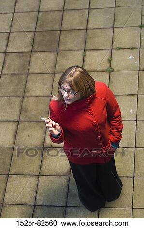 High angle view of a mid adult woman smoking a cigarette View Large Photo Image Stock Image - High angle view of a mid adult woman smoking a cigarette. Fotosearch