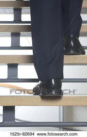 Low section view of a businessman's legs walking up stairs View Large Photo Image Picture - Low section view of a businessman's legs walking up stairs. Fotosearch