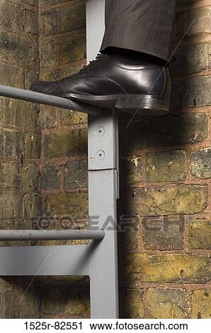 Low section view of a man climbing up a ladder View Large Photo Image Stock Image - Low section view of a man climbing up a ladder. Fotosearch
