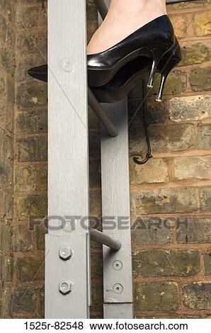 Low section view of a woman climbing up a ladder View Large Photo Image Stock Photo - Low section view of a woman climbing up a ladder. Fotosearch