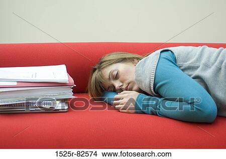 Picture - Mid adult woman sleeping on a couch. Fotosearch