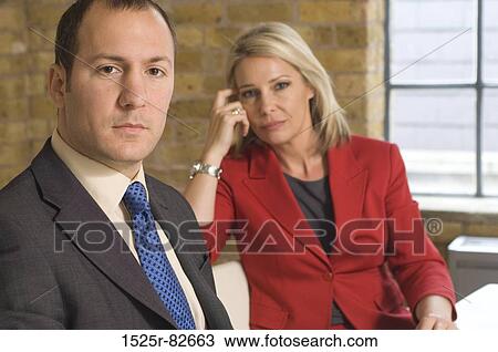 Portrait of a businessman looking serious with a businesswoman sitting beside him View Large Photo Image Stock Image - Portrait of a businessman looking serious with a businesswoman sitting beside him. Fotosearch