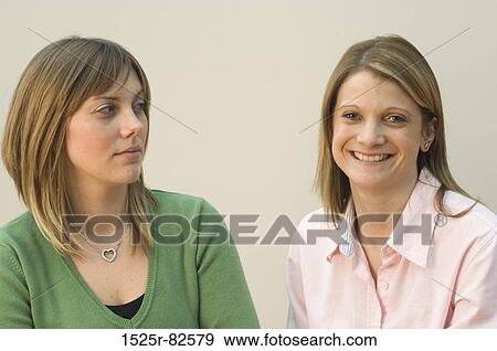 Stock Photo - Portrait of a mid adult woman smiling with another woman beside her. Fotosearch