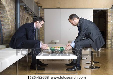 Two businessmen playing foosball View Large Photo Image Stock Photo - Two businessmen playing foosball. Fotosearch