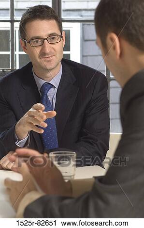 Two businessmen talking in a meeting View Large Photo Image Stock Image - Two businessmen talking in a meeting. Fotosearch