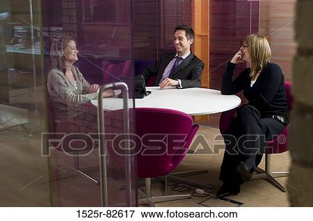 Two businesswomen with a businessman talking in a meeting View Large Photo Image Stock Photo - Two businesswomen with a businessman talking in a meeting. Fotosearch