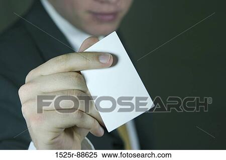 Business man in dark suit holds out blank business card View Large Photo Image Stock Photography - Business man in dark suit holds out blank business card. Fotosearch