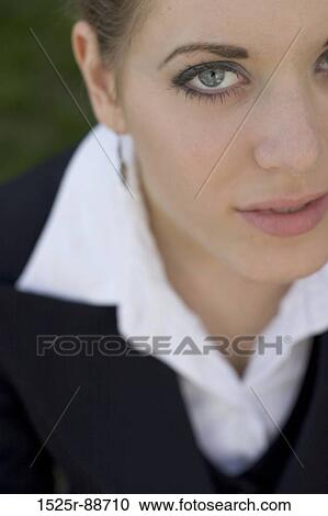 Business woman sitting down in her business clothes looking up at the camera with the focus on one eye View Large Photo Image Stock Image - Business woman sitting down in her business clothes looking up at the camera with the focus on one eye. Fotosearch