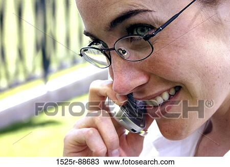 Business woman with glasses places earphones next to her ear View Large Photo Image Stock Image - Business woman with glasses places earphones next to her ear. Fotosearch