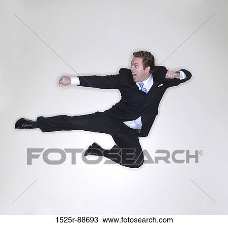 Businessman gives a karate kick in the air inside the office View Large Photo Image Stock Image - Businessman gives a karate kick in the air inside the office. Fotosearch