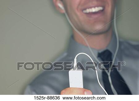 Businessman is playing his personal music device View Large Photo Image Stock Photograph - Businessman is playing his personal music device. Fotosearch