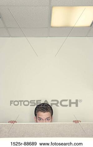 Businessman looking over the cubical wall staring forward with his hands on the top of the cubical wall View Large Photo Image Stock Photo - Businessman looking over the cubical wall staring forward with his hands on the top of the cubical wall. Fotosearch