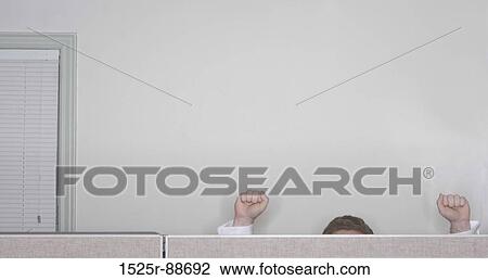 Businessman raises his arms in success in the office while working in his cubicle View Large Photo Image Stock Image - Businessman raises his arms in success in the office while working in his cubicle. Fotosearch