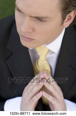 Businessman sitting in the park with his hands clasped in contemplation and thinking View Large Photo Image Stock Image - Businessman sitting in the park with his hands clasped in contemplation and thinking. Fotosearch