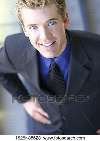 Stock Photo - Businessman standing with his hands on his hips with a toothy smile. Fotosearch