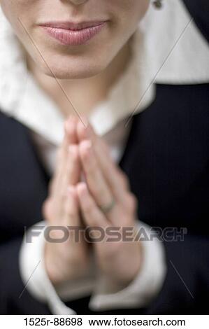 Businesswoman looking up with her hands clasped together close-up View Large Photo Image Stock Photo - Businesswoman looking up with her hands clasped together close-up. Fotosearch