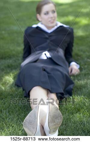 Businesswoman lying on her back relaxing in the park View Large Photo Image Stock Image - Businesswoman lying on her back relaxing in the park. Fotosearch
