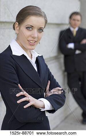 Businesswoman standing in front of a businessman with her arms folded View Large Photo Image Stock Image - Businesswoman standing in front of a businessman with her arms folded. Fotosearch