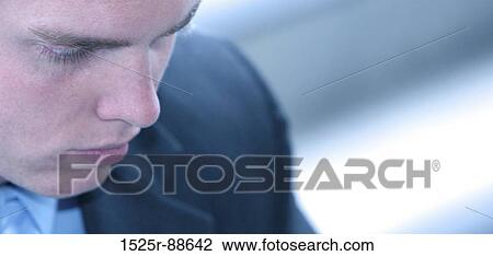 Close-up face shot of young business man in blue suit looking down View Large Photo Image Stock Image - Close-up face shot of young business man in blue suit looking down. Fotosearch