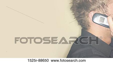 Stock Image - Head of man as he talks on cellphone with a lot of copy space. Fotosearch