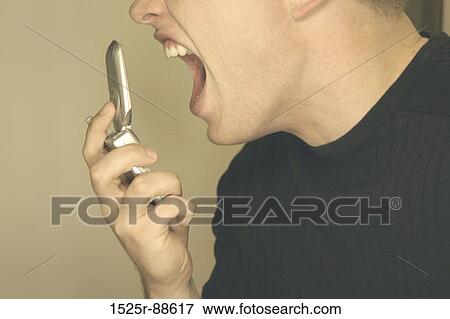 Man screaming at cell phone in black sweater and brown background View Large Photo Image Stock Photo - Man screaming at cell phone in black sweater and brown background. Fotosearch