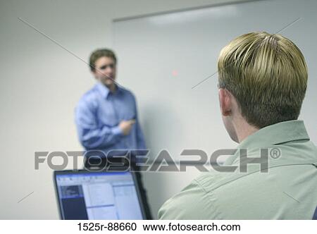 Two businessmen in green and blue shirts discuss business matters next to a marker board with a laptop in the foreground View Large Photo Image Stock Image - Two businessmen in green and blue shirts discuss business matters next to a marker board with a laptop in the foreground. Fotosearch