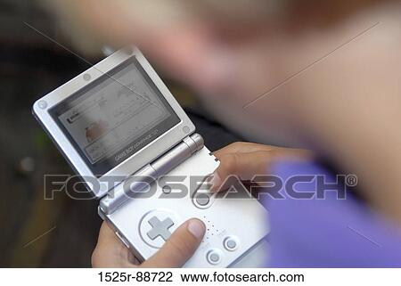 Close-up of a child playing a handheld video game View Large Photo Image Stock Image - Close-up of a child playing a handheld video game. Fotosearch