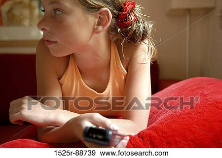 Close-up of a girl holding a remote control View Large Photo Image Stock Photo - Close-up of a girl holding a remote control. Fotosearch