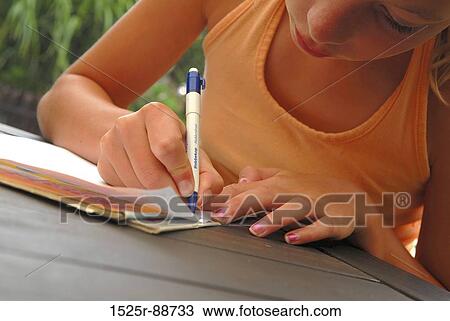 Close-up of a girl writing on a sheet of paper View Large Photo Image Stock Image - Close-up of a girl writing on a sheet of paper. Fotosearch