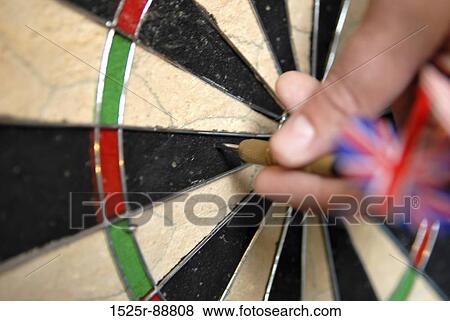 Close-up of a person's hand picking up a dart from a dartboard View Large Photo Image Stock Photo - Close-up of a person's hand picking up a dart from a dartboard. Fotosearch