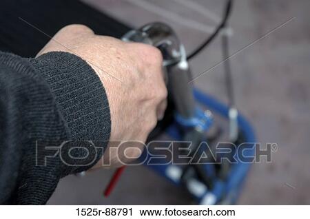 Stock Image - Close-up of a person's hand using a walker. Fotosearch