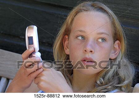 Stock Image - Close-up of a teenage girl holding a mobile phone. Fotosearch