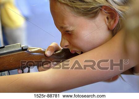 Close-up of a teenage girl shooting a rifle View Large Photo Image Stock Image - Close-up of a teenage girl shooting a rifle. Fotosearch