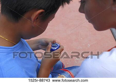 Close-up of two boys checking the time View Large Photo Image Stock Image - Close-up of two boys checking the time. Fotosearch