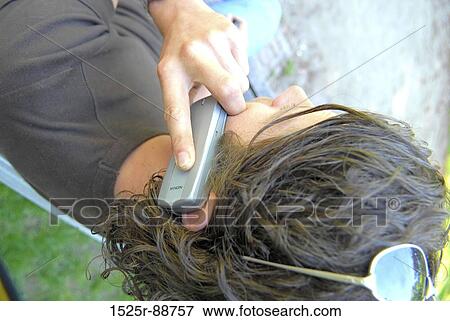 High angle view of a young man using a mobile phone View Large Photo Image Stock Photo - High angle view of a young man using a mobile phone. Fotosearch