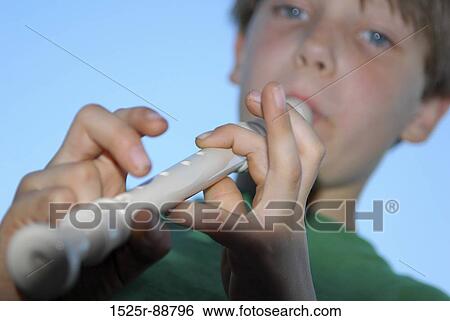 Low angle view of a boy playing a recorder View Large Photo Image Stock Photograph - Low angle view of a boy playing a recorder. Fotosearch