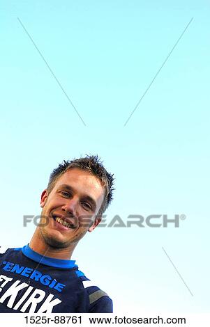 Stock Image - Low angle view of a young man smiling. Fotosearch
