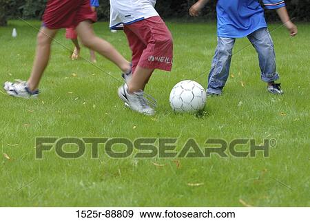 Low section view of two boys playing soccer View Large Photo Image Stock Photo - Low section view of two boys playing soccer. Fotosearch