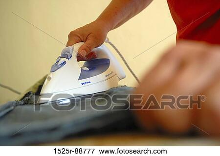 Mid section view of a man ironing jeans View Large Photo Image Stock Photo - Mid section view of a man ironing jeans. Fotosearch