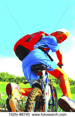 Rear view of a boy riding a bicycle View Large Photo Image Stock Image - Rear view of a boy riding a bicycle. Fotosearch