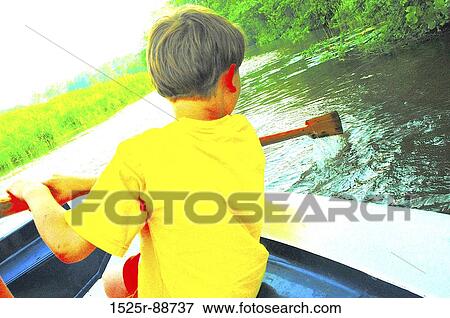 Rear view of a boy rowing a boat in a river View Large Photo Image Stock Photo - Rear view of a boy rowing a boat in a river. Fotosearch