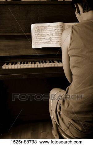 Rear view of a woman playing a piano View Large Photo Image Stock Photo - Rear view of a woman playing a piano. Fotosearch