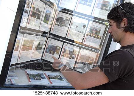 Young man standing at an information booth View Large Photo Image Stock Photo - Young man standing at an information booth. Fotosearch