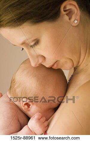 Close-up of a young woman carrying her baby View Large Photo Image Stock Image - Close-up of a young woman carrying her baby. Fotosearch